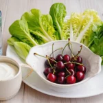 Acide urique : 7 aliments à éviter et 5 réflexes efficaces 3 Acide urique : Assiette équilibrée avec légumes verts, cerises et un grand verre d'eau