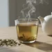 Tasse de thé vert fraîchement infusé avec feuilles en vrac sur une table claire
